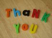 Palabras de colores sobre una mesa formando la frase “thank you”.