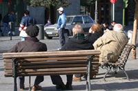 Jubilados sentados en un banco en la calle.