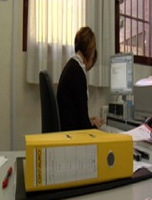 Fotografía en la que se ve a Carmen trabajando en una mesa con documentos.