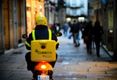 Moto de correos circulando por una vía pública.