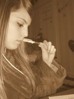 Sandra de perfil con un bolígrafo situado delante de la boca, estudiando. Color sepia.
