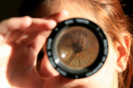 Caleidoscopio. Persona mirando un caleidoscopio, de forma que se ve la pupila y el iris ampliados como si fuera una lupa.