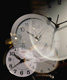 En la imagen se ven varios relojes uno de ellos reflejado como en un cristal.