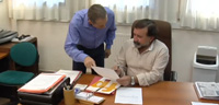 Carlos entregando unos documentos a su compañero Rafael, director de Recursos Humanos.