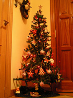 Árbol de Navidad cargado de adornos en una casa.