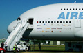 Foto de avión con pasarela de entrada de pasajeros.