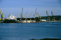 Muelle de un puerto marítimo con contenedores y grúas.