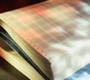 Varios documentos en papel blanco y con varios registros apilados uno encima de otros, sobre una mesa.