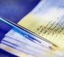 Aparece un documento escrito con un bolígrado justo encima sobre una mesa de color azul.