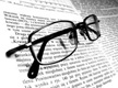 Son unas gafas sobre un libro abierto.