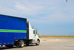 Camion. Imagen de un camión con el color de la cabina blanco y el color del remolque azul con una línea verde transversal.