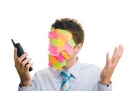 Cooperación empresarial. Es un hombre con la cara oculta por un montón de notas de colores.