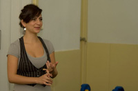 Ana García de pie. Ana García, personaje del caso práctico, chica joven morena vestida con camiseta azul, de pie.