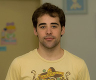 Ahmed Rasyanni. Hombre joven de pelo negro con camiseta amarilla.