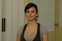 Ana García. Mujer joven de pelo negro y recogido, viste camiseta gris y chaleco negro.