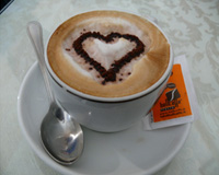Taza de café formando un corazón en la espuma.