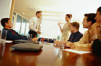 Mesa de trabajo. Personas alrededor de una mesa de trabajo.