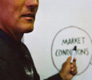 Un hombre indica sobre una pizarra las siguientes palabras: Market Concepts.