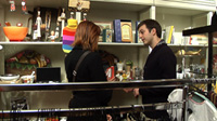Un dependiente atendiendo a una cliente en un supermercado.