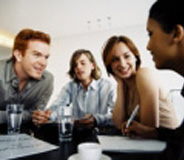 Dos hombres y dos mujeres reunidas alrededor de una mesa.