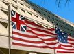 Las banderas inglesa y americana ondeando ante un edificio.