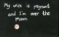 Oración en inglés escrita sobre una pizarra: My wife is pregnant and I'm over the moon.