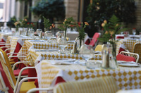 Mesas en una terraza de un restaurante, con los manteles y cubiertos puestos.