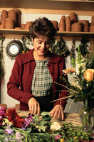 Una mujer prepara productos en una floristería.