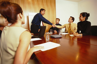 Personas alrededor de una mesa negociando un contrato.