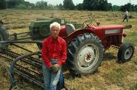 Persona en el campo delante de su tractor.