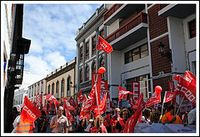 Un grupo de personas se manifiestan con banderas en la Puerta del Sol.