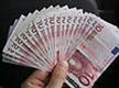 Una mano sostiene un fajo de billetes de 10 euros.