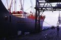 Pequeño buque de carga general en el puerto de Plymouth en 1968. En el muelle se aprecian dos grúas multipropósito con pluma de cuadrilátero y las vías de ferrocarril.