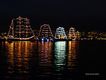 Vista nocturna de cuatro buques escuela en el puerto de Valparaíso, Chile, con iluminación en el perímetro del velamen..
