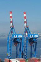 Dos grúas de contenedores con la pluma alzada en el puerto de Valparaíso. Chile.