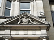 Escudo esculpido en el frontispicio de la puerta de entrada al antiguo edificio (1.898) de la  Compañía de Seguros Royal Insurance Company en la ciudad de Edimburgo, Escocia, Reino Unido, actualmente integrado en el edificio de la Standard Life Investments. En el escudo se aprecia el nombre de la compañía flanqueado por dos leones a modo de composición heráldica.