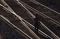 Trabajador caminando por un vial ferroviario.