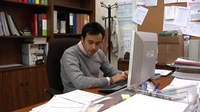 Fernando sentado en un despacho escribiendo en el ordenador.