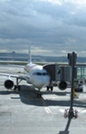 Avión en un aeropuerto con el finger de acceso de viajeros conectado.