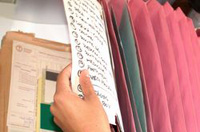 Clasificación. Carpeta clasificadora y una mano introduciendo folios.