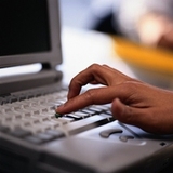 Aplicación. Una mano pulsa un teclado de un ordenador.