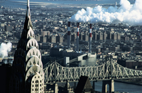 Una gran ciudad en la que se ve dos grandes chimeneas emanando humo blanco.