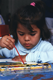 Aparece una niña pintando con acuarelas.