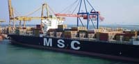 Transporte marítimo. Barco de carga realizando labores de estiba en el Puerto de Valencia.