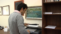 Fernando 2. Hombre joven de espaldas realizando fotocopias.