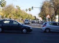 Vía principal de una ciudad con varios vehículos circulando.