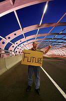 The future. Hombre haciendo autostop con un cartel en el que se puede leer la palabra futuro en inglés.