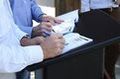 Manos de dos personas firmado documentos.