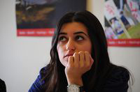 Girl Thinking. Chica pensativa con el puño de la mano cerrado apoyado en la boca.