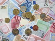 Foto en la que aparecen billetes y monedas de euro como que símbolo de intercambio de bienes y servicios.